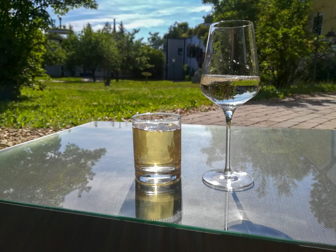 Zwei Gläser auf einem Glastisch mit Blick auf den Innenhof der Rogner Therme Bad Blumau