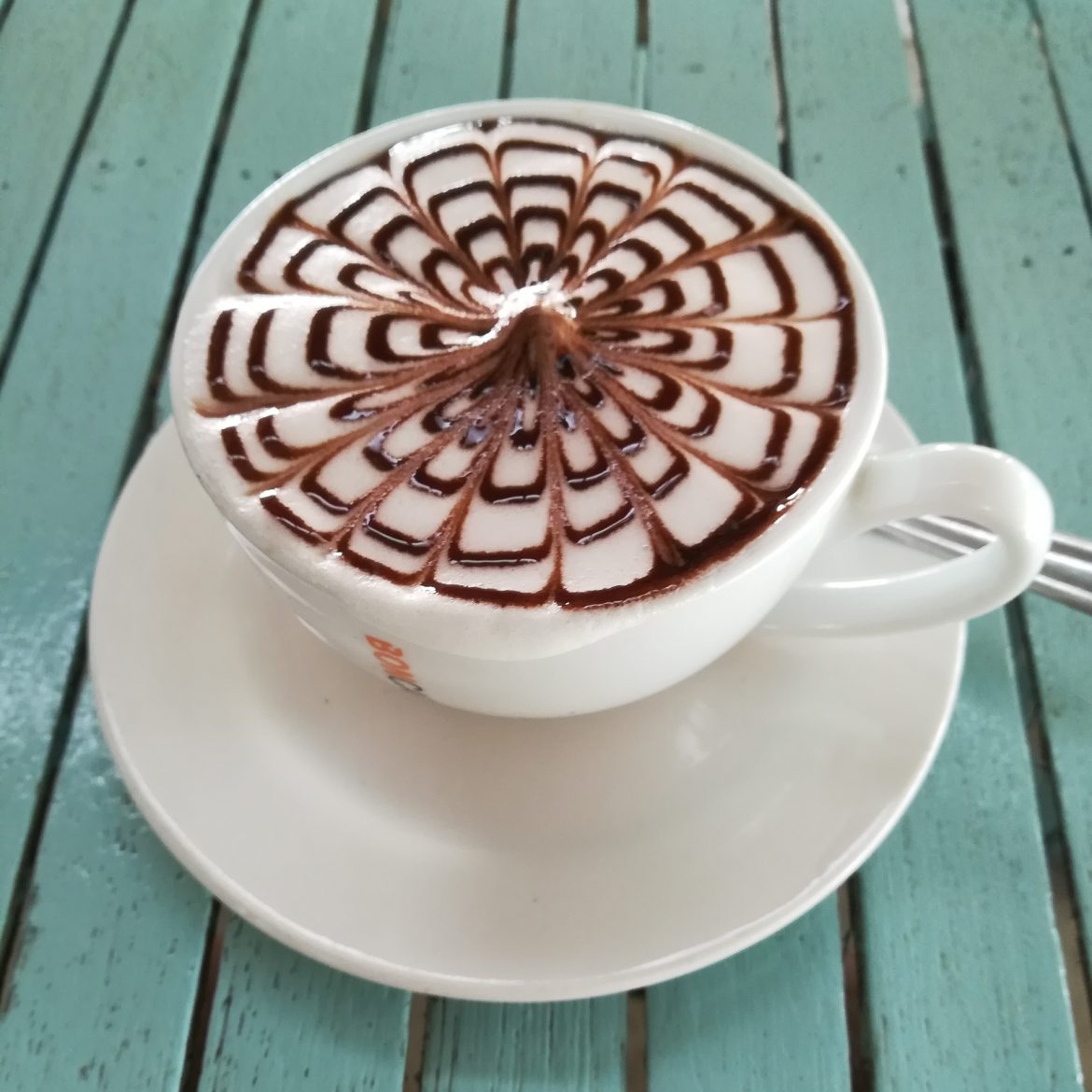 Eine Tasse Kaffee, verziert mit einem Gitter aus Schokolade.