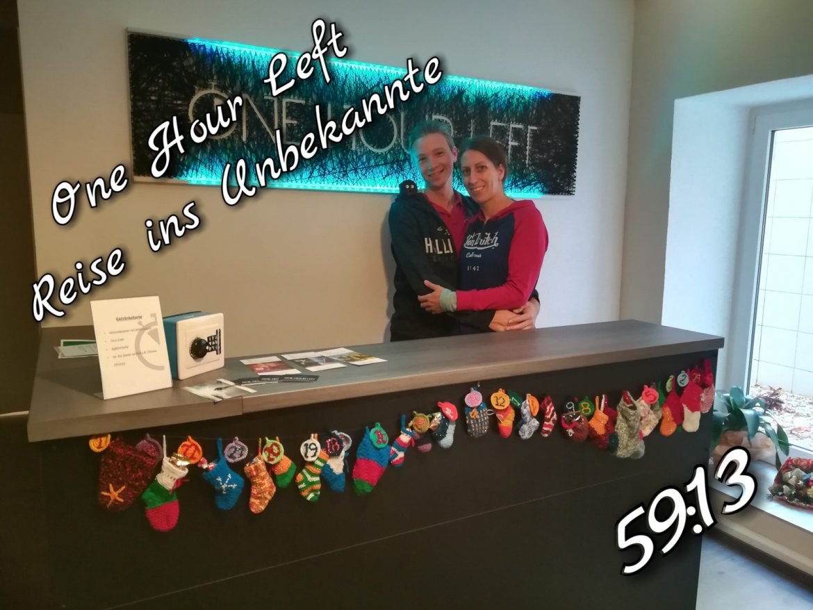 Siegerfoto vor dem Logo von One Hour Left in München, nach unserem Erfolg im Escape Room Reise ins Unbekannte.