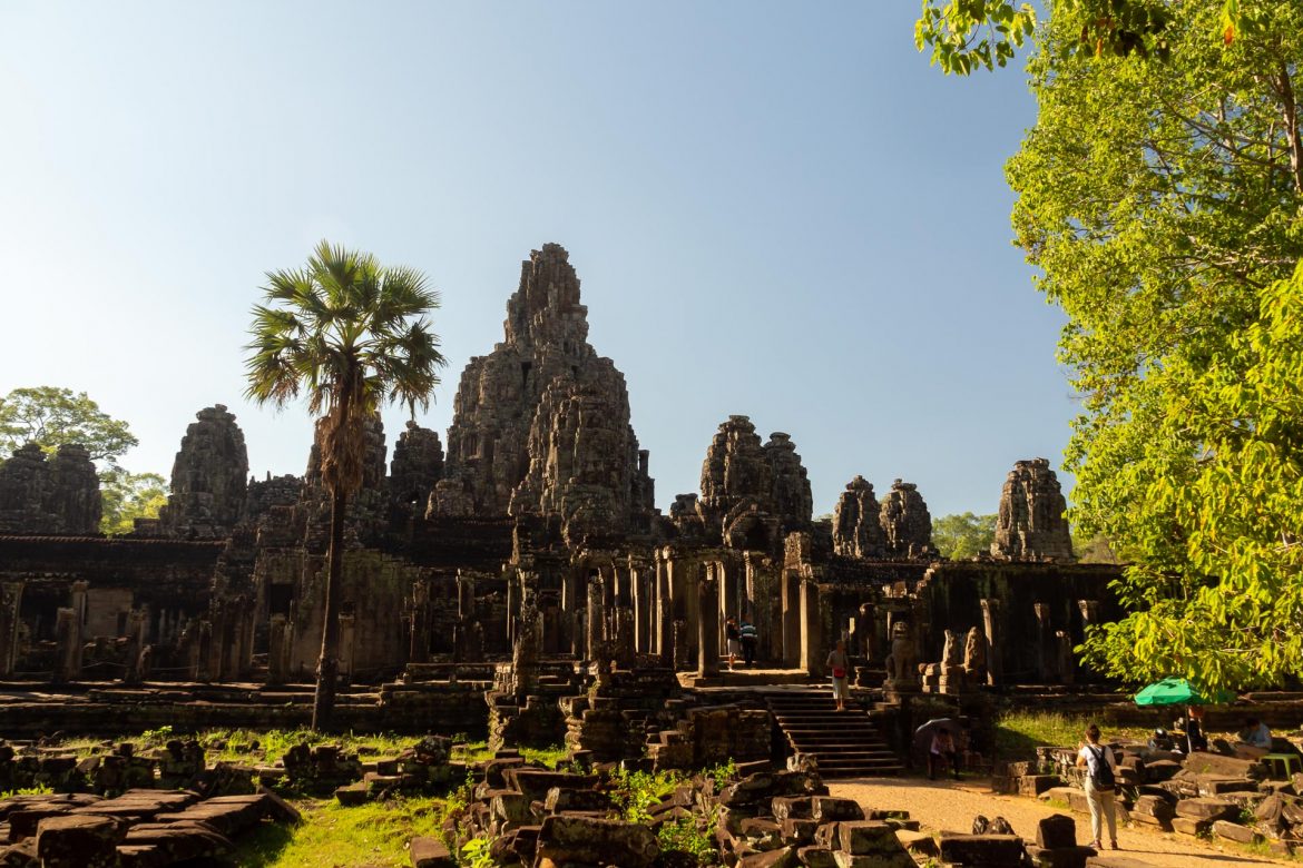 Der Bayon Tempel in Angkor Thom von der Ferne im Sonnenlicht fotografiert.