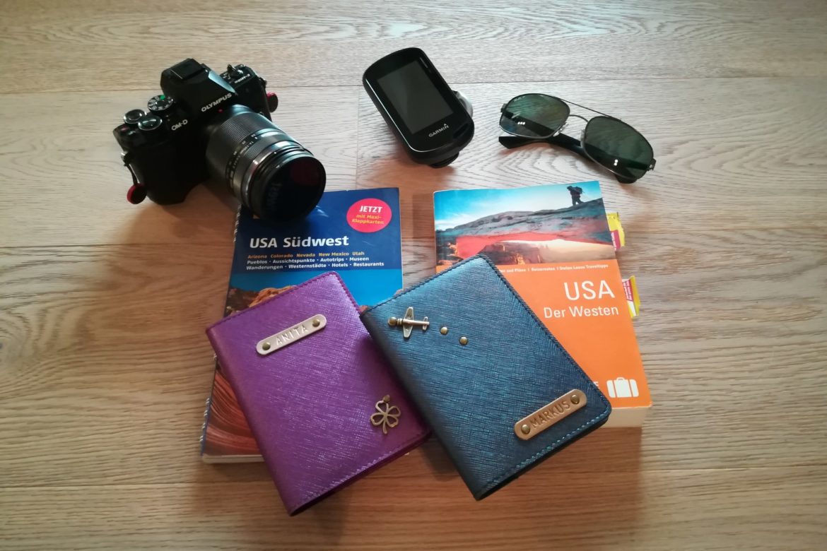 Unsere Rucksäcke zusammen mit Reisepässen, Kamera, GPS und Sonnenbrille drapiert als Vorbereitung für unserer Reise in die USA