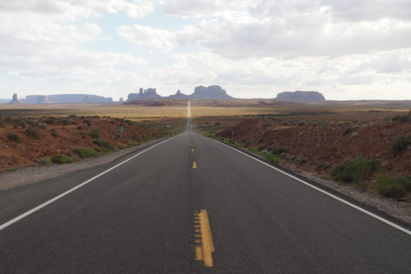 Beinahe unendlich weit scheint die Straße am Forrest Gump Point zu gehen, bis sie schließlich am Horizont in den Tafelbergen des Monument Valley verschwindet.
