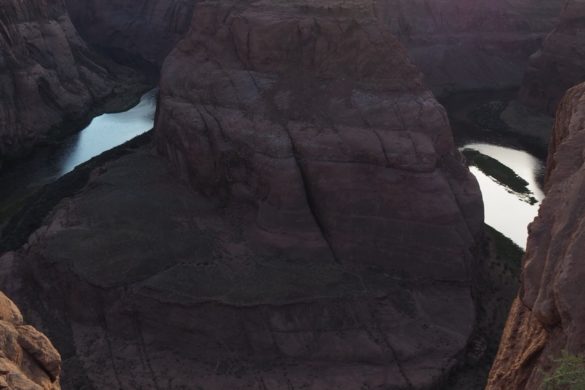 Der berühmte Horseshoe Bend des Colorado Rivers, der ruhig in seinem Flussbett fließt bei Sonnenuntergang und starkem gegenlicht der Sonne