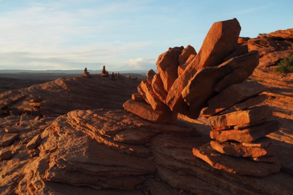 Nahe des Horseshoe Bend haben wir diesen Steinbogen aus Steinplatten gefunden, der im Licht des Sonnenunterganges in einem extrem kräftigen rot-braun leuchtet. Im Hintergrund erkennt man noch einige Steinmännchen.