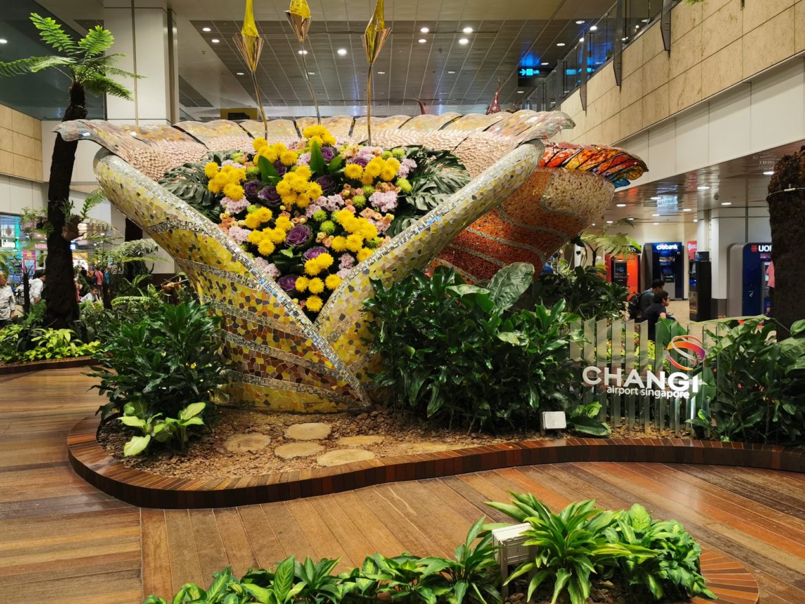 Wunderschöne Blumen in gelb, lila und rosa Farben. Liebevoll drapiert in einer riesigen Vase, die ebenfalls wie eine Blume aussieht
